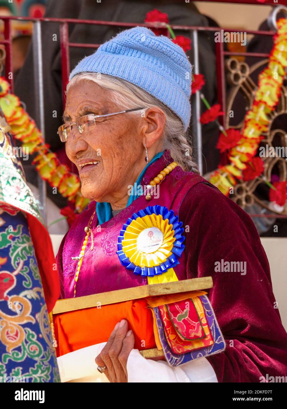 Leh, Indien - 7. August 2012: Frau in nationaler Kleidung sorgfältig und verantwortungsvoll führt ihre Pflichten bei der seine Heiligkeit der 14. Dalai Lama Lehren A Stockfoto