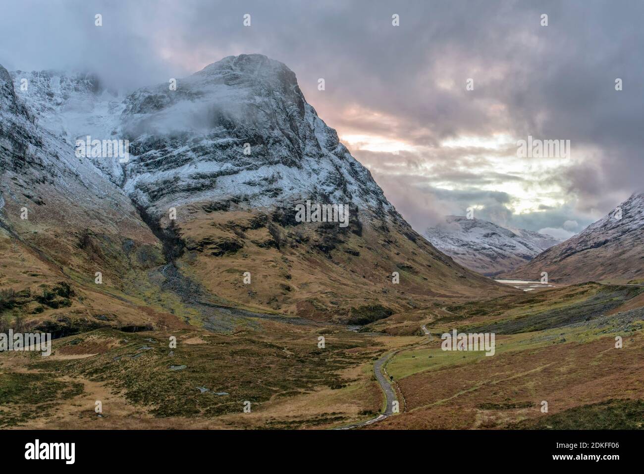 Blick auf das winterliche Glencoe Valley in Schottland mit dramatischen wolkiger Himmel und schneebedeckte Berge Stockfoto