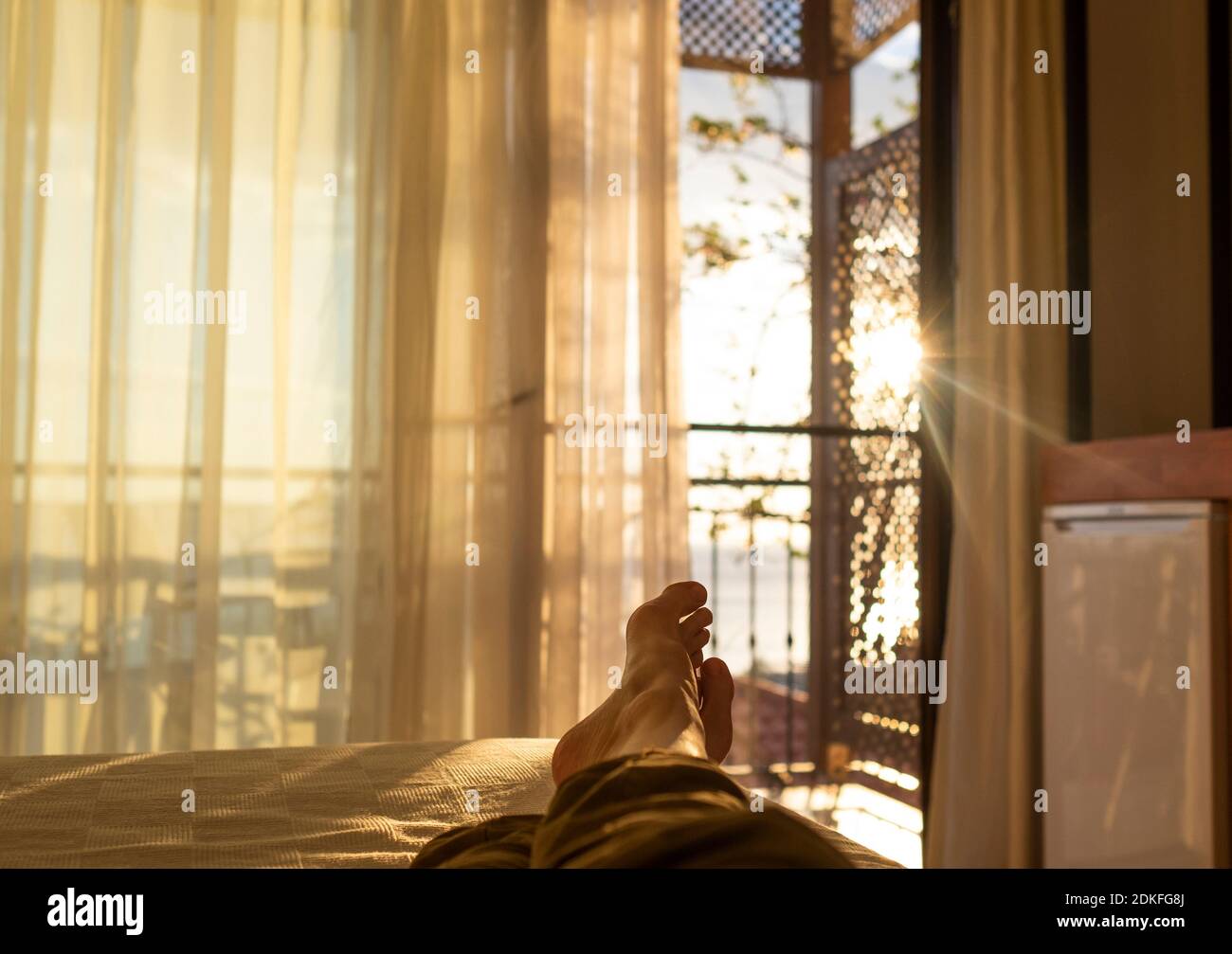 Liegen und Entspannen im Bett gegenüber einem Fenster bei Sonnenuntergang  Stockfotografie - Alamy