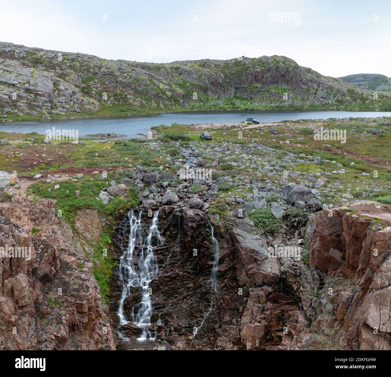 Parken von Touristen mit dem Auto am See und Wasserfall in der Tundra der Kola Halbinsel in der Nähe der Küste der Barentssee, Russland Stockfoto