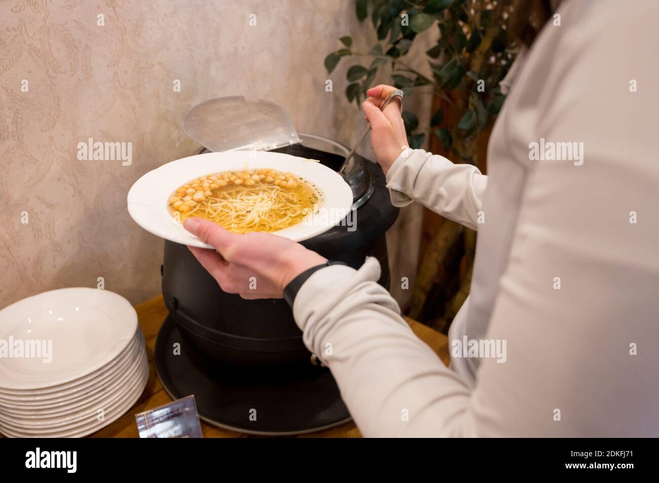 Detailansicht der Frau, die Suppe am Buffet gießt. Stockfoto