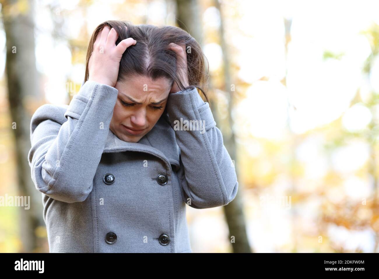 Traurige Frau, die sich im Winter alleine in einem Park beschwert Stockfoto