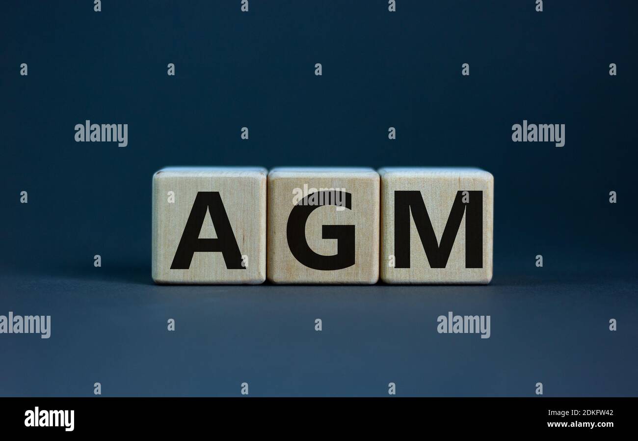 NGM-Symbol. Konzeptwort "AGM" - "Jahreshauptversammlung" auf Kuben auf einem schönen Holztisch. Weißer Hintergrund. Geschäfts- und Jahreshauptversammlung Stockfoto