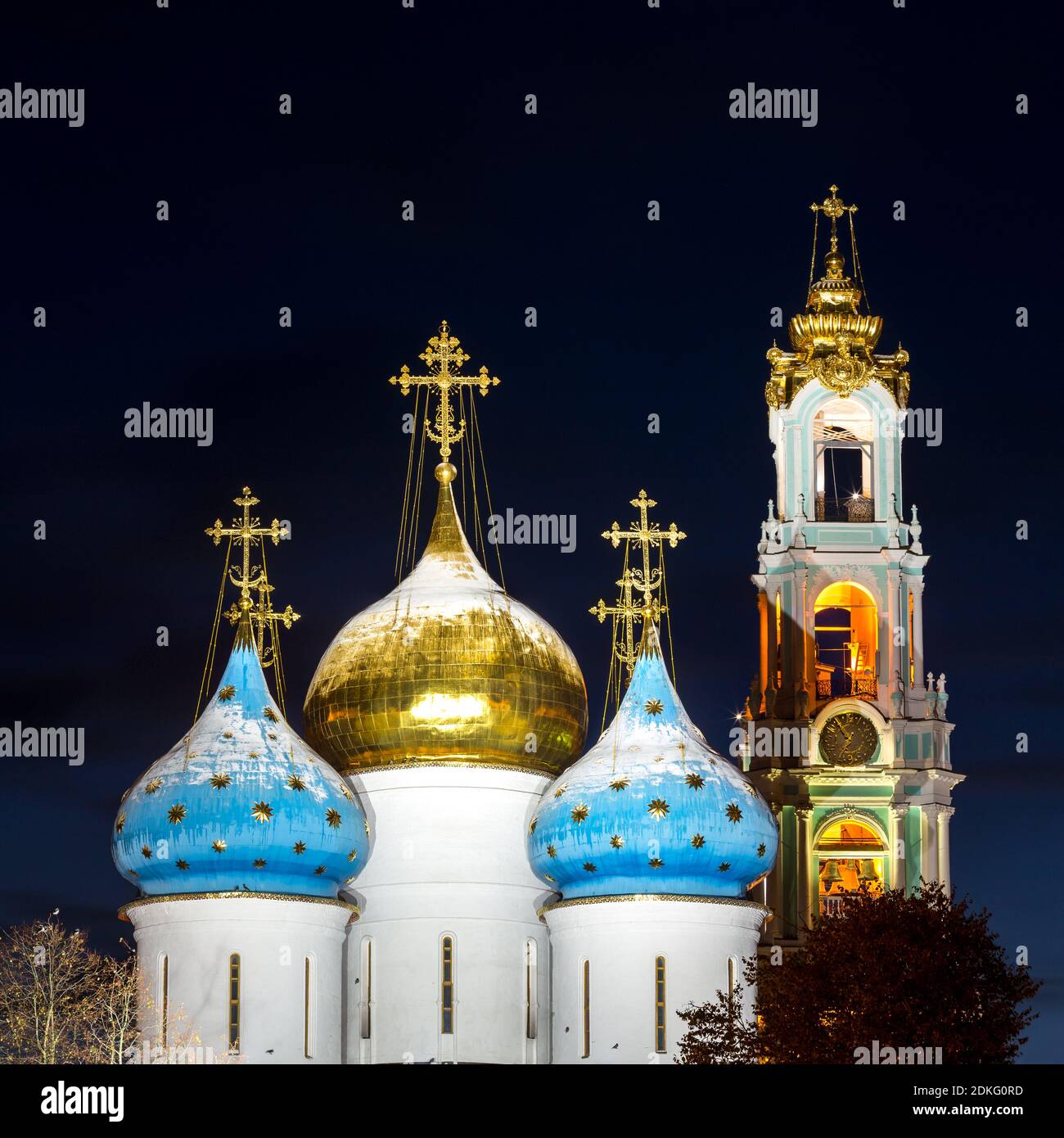 Panorama der Mariä-Himmelfahrt-Kathedrale und der Glockenturm der Dreifaltigkeit Lavra von St. Sergius nach Sonnenuntergang mit einer spektakulären Hintergrundbeleuchtung (Sergiyev Posa Stockfoto