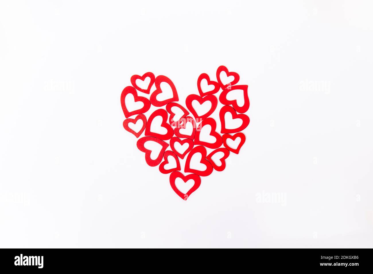 Draufsicht gemustert große Form eines Herzens aus Holz schneiden rote Herzen auf dem weißen Hintergrund. Valentinstag, Liebeskonzept. Geschenk, Nachricht für Stockfoto