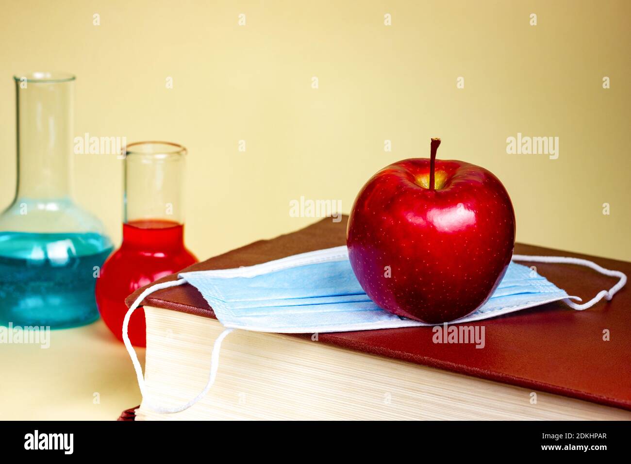 Chemie-Klasse. Großes Chemie-Lehrbuch oder medizinisches Nachschlagewerk auf gelbem Hintergrund. Schokolade, Studentenausbildung. Stockfoto