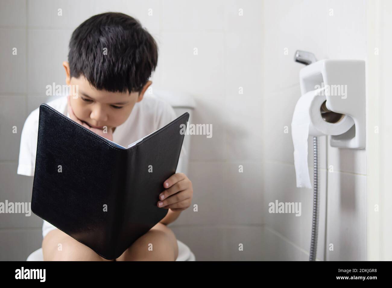 Junge Buch Lesen, Während Auf Toilette Schüssel Im Badezimmer Zu Hause  Sitzen Stockfotografie - Alamy