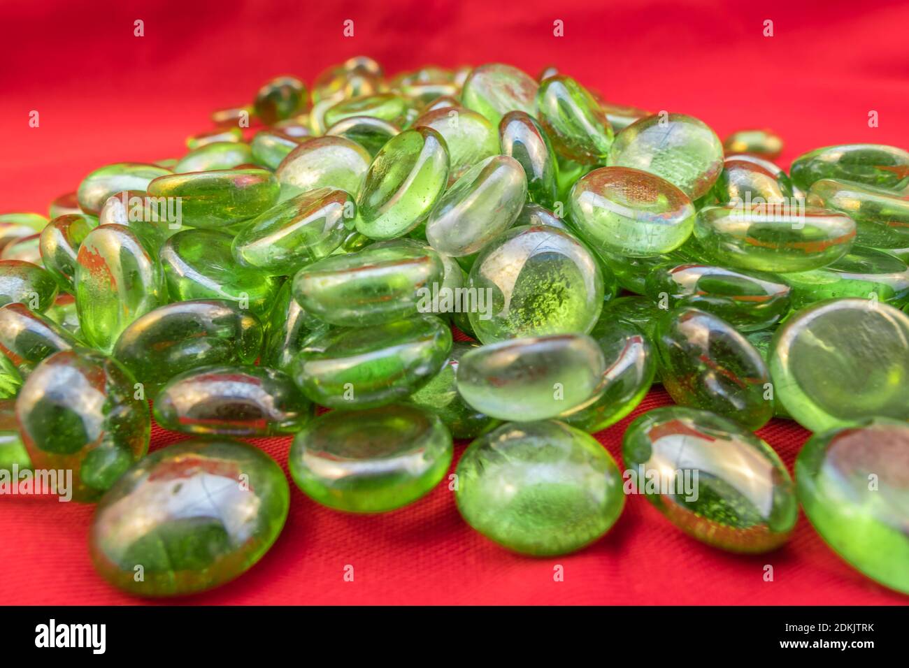 Grüne Glasperlen auf hellrotem Hintergrund Stockfoto