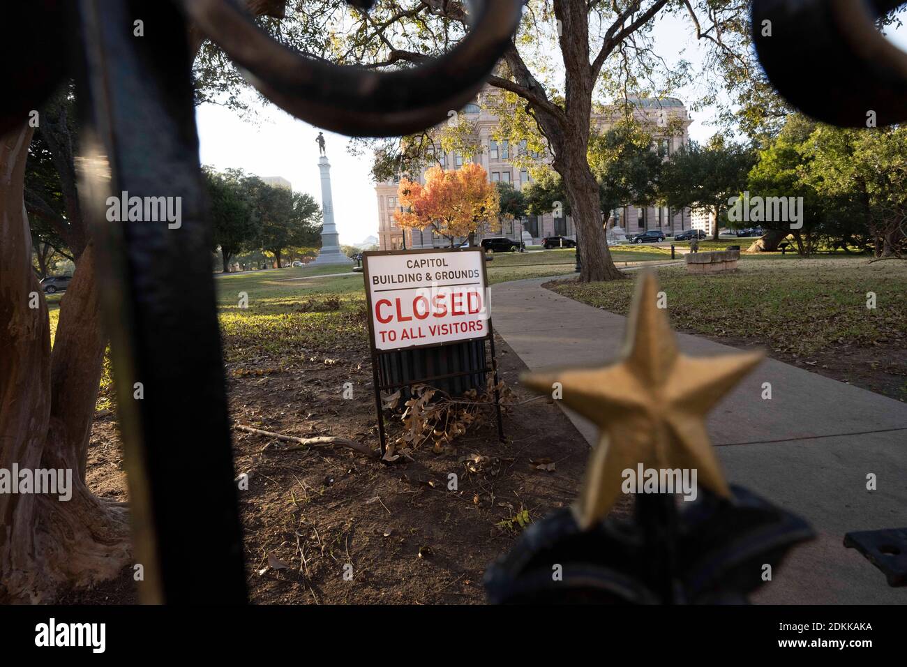 Austin, TX USA 15. Dezember 2020: Schild mit der Aufschrift 'Capitol Building and Grounds CLOSED to all Visitors' sitzt hinter den verschlossenen Toren des Texas Capitol in Austin am Abend bevor der Gouverneur von Texas, Greg Abbott, die Wiedereröffnung des Geländes für die Öffentlichkeit anordnete. Das Capitol ist seit Monaten geschlossen, nachdem Vandalismus auf dem Gelände und Gebäude während der Proteste gegen Polizeigewalt nach dem Mord an George Floyd im Mai 2020. Kredit: Bob Daemmrich/Alamy Live Nachrichten Stockfoto