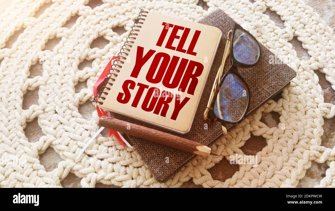 Text Erzählen Sie Ihre Geschichte auf dem Cover von Buch, Brille und Stift. Geschäftskonzept für Storytelling Telling Story auf Notizblock Titelseite geschrieben. Stockfoto