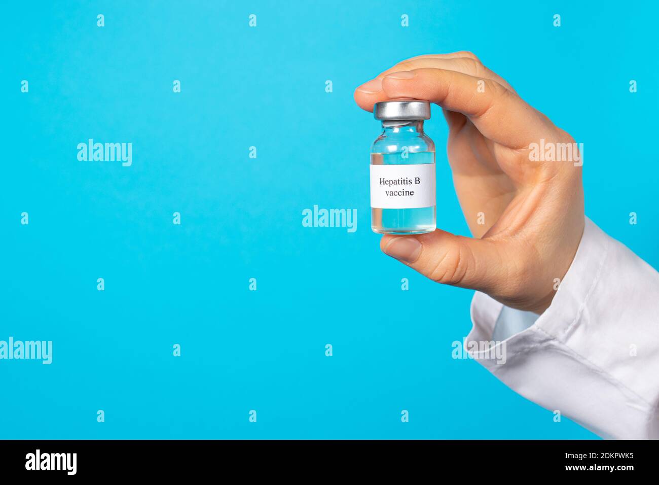 Ein Arzt oder Labortechniker hält ein Fläschchen mit einem Hepatitis-B-Impfstoff in der Hand. Mit einem Platz für Text auf blauem Hintergrund. Stockfoto