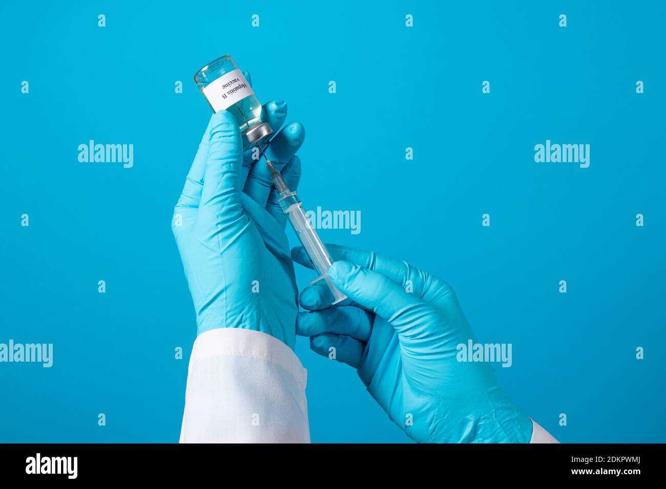 Ein Arzt oder Labortechniker hält ein Fläschchen mit einem Hepatitis-B-Impfstoff in der Hand. Mit einem Platz für Text auf blauem Hintergrund. Stockfoto