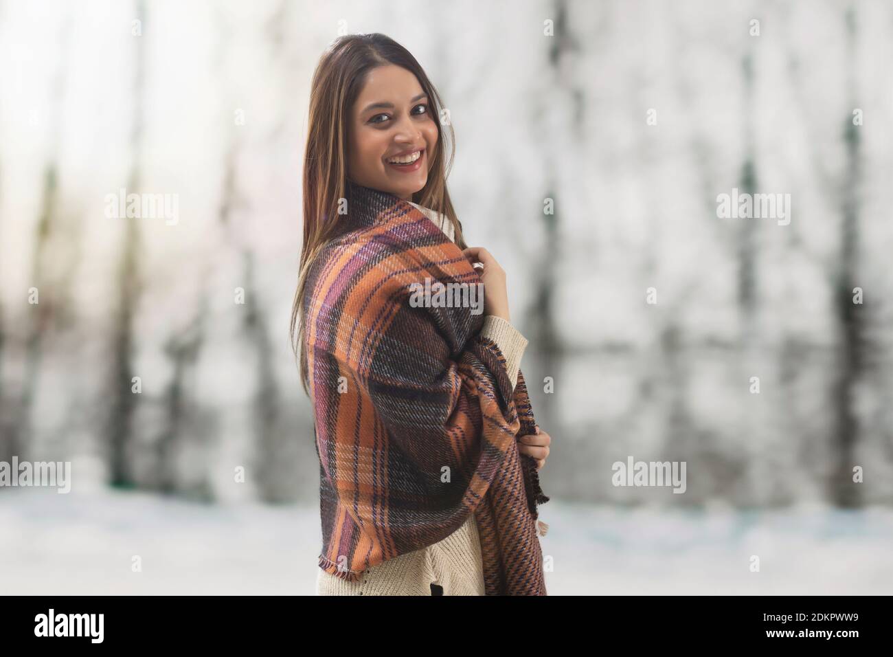 FRAU DREHT SICH UM UND LÄCHELT DIE WINTERSAISON GENIESSEN Stockfoto