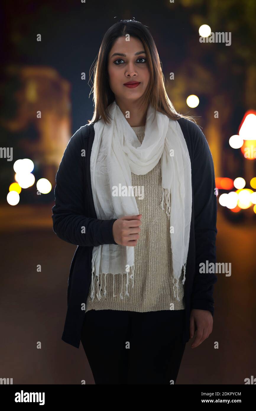 EINE JUNGE, SELBSTBEWUSSTE FRAU, DIE GERADE AUF EINE BELEBTE STRASSE SCHAUT Stockfoto