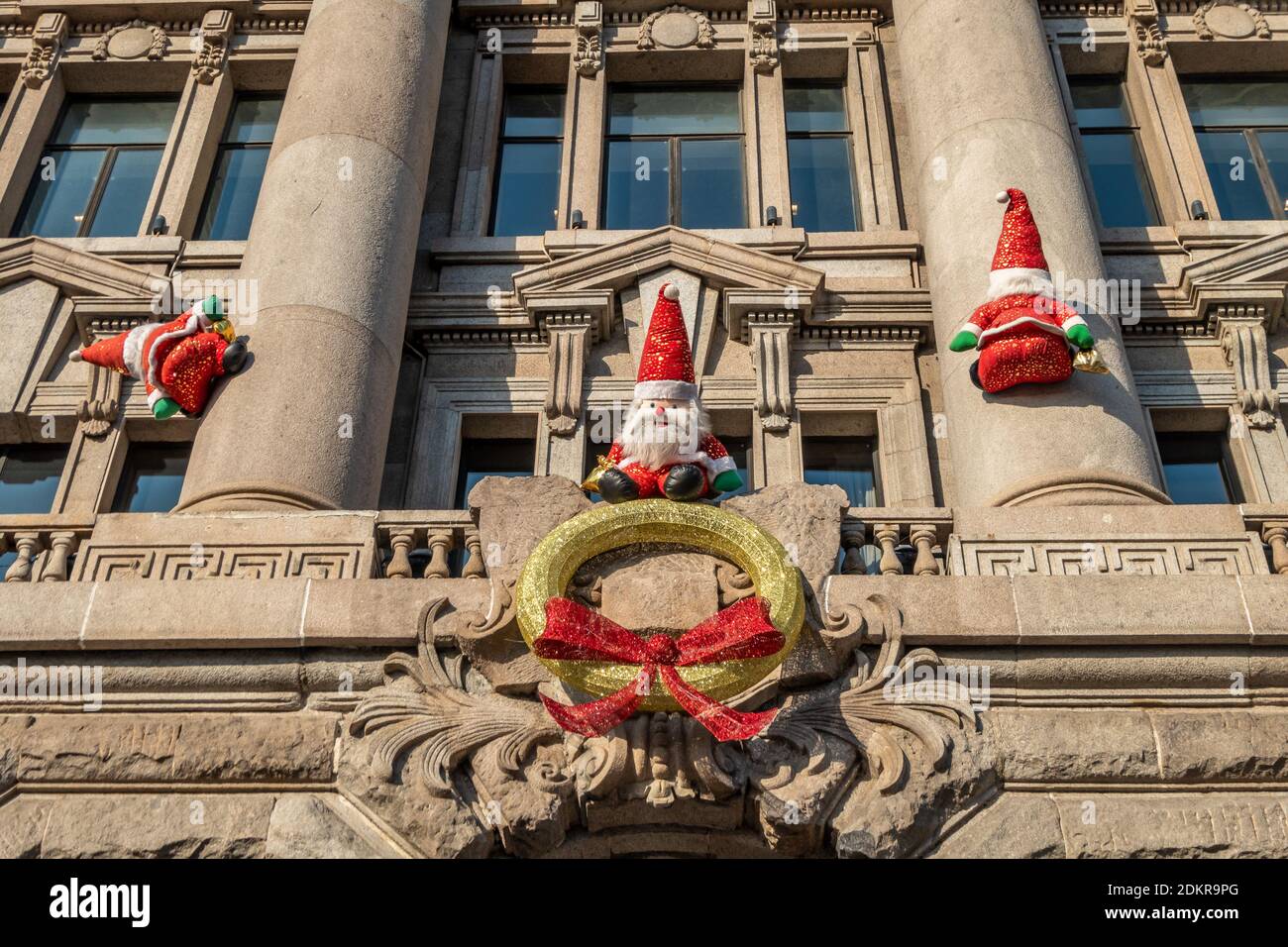Mehr als ein Dutzend „Santa Clauses“ klettern auf die Außenwände der Roosevelt Mansion und machen den Bund voll von der festlichen Atmosphäre in Huangpu Distrikt Stockfoto