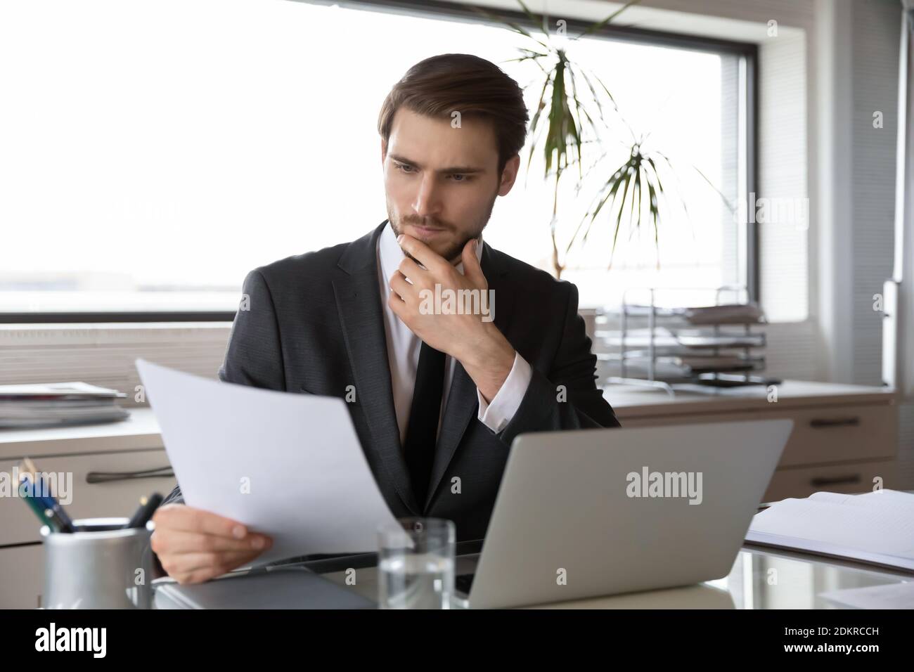 Pensive kaukasischen Geschäftsmann analysieren Dokumente im Büro e Stockfoto