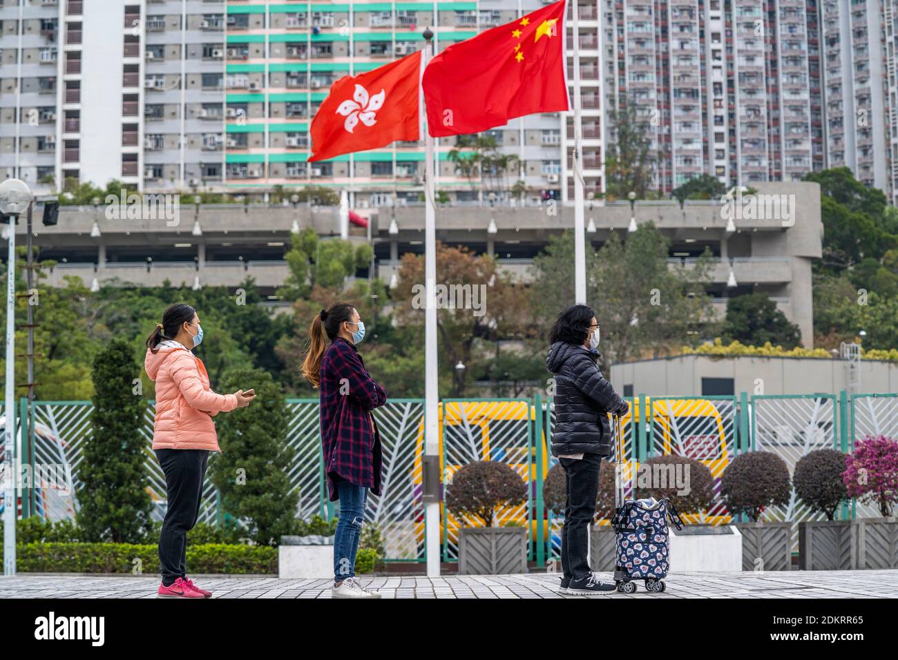 Menschen, die vor der Flagge von Hongkong und China gesehen werden, als sie sich anstellen, um ihren Covid-19-Abstrichtest in einem provisorischen Covid-19-Testzentrum in der Nähe einer öffentlichen Wohnanlage durchführen zu lassen.mehrere provisorische Covid-19-Coronavirus-Testzentren werden in Hongkong eingerichtet, um kostenlose Tests durchzuführen Dienstleistungen für Bewohner. Stockfoto