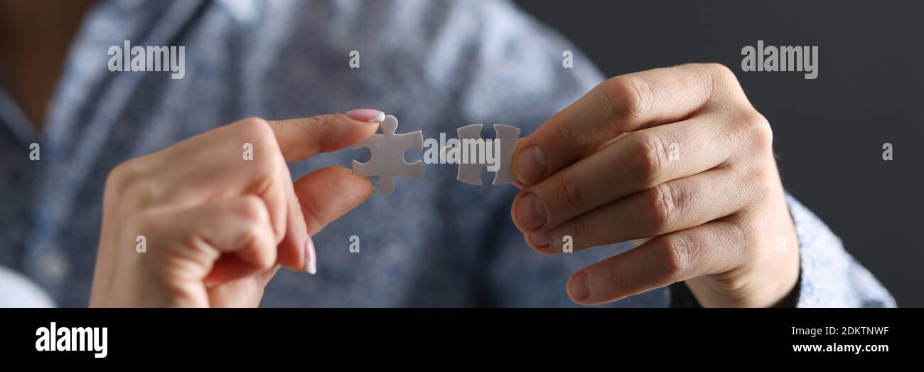 Mans und eine Frau Hand verbindet zwei Puzzle-Stücke Nahaufnahme Stockfoto