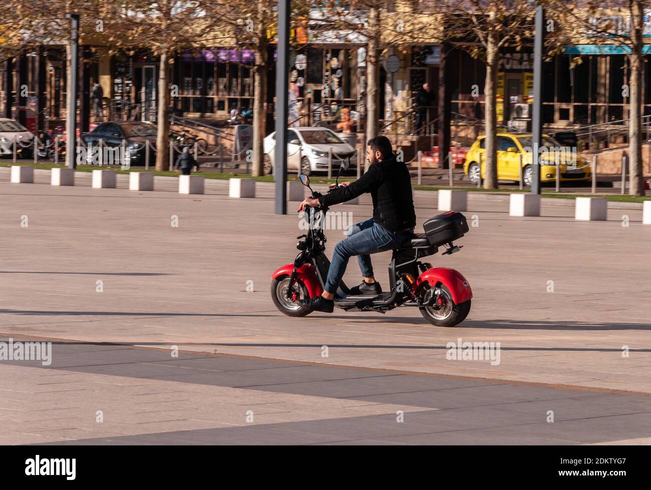 Krasnodar, Russland - Dezember 10 2020: Alternative pendeln, Mann mieten und Reiten auf einem E-Bike in einem Stadtpark Stockfoto