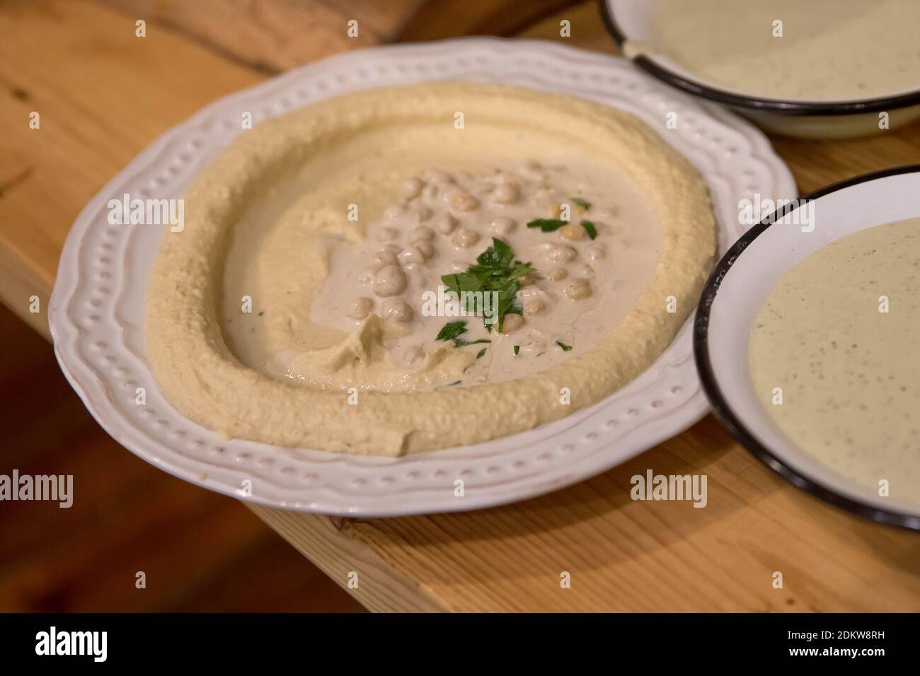 Eine Portion Humus, Tahini, Olivenöl und Petersilie eine mittelöstliche Paste aus Kichererbsen Stockfoto