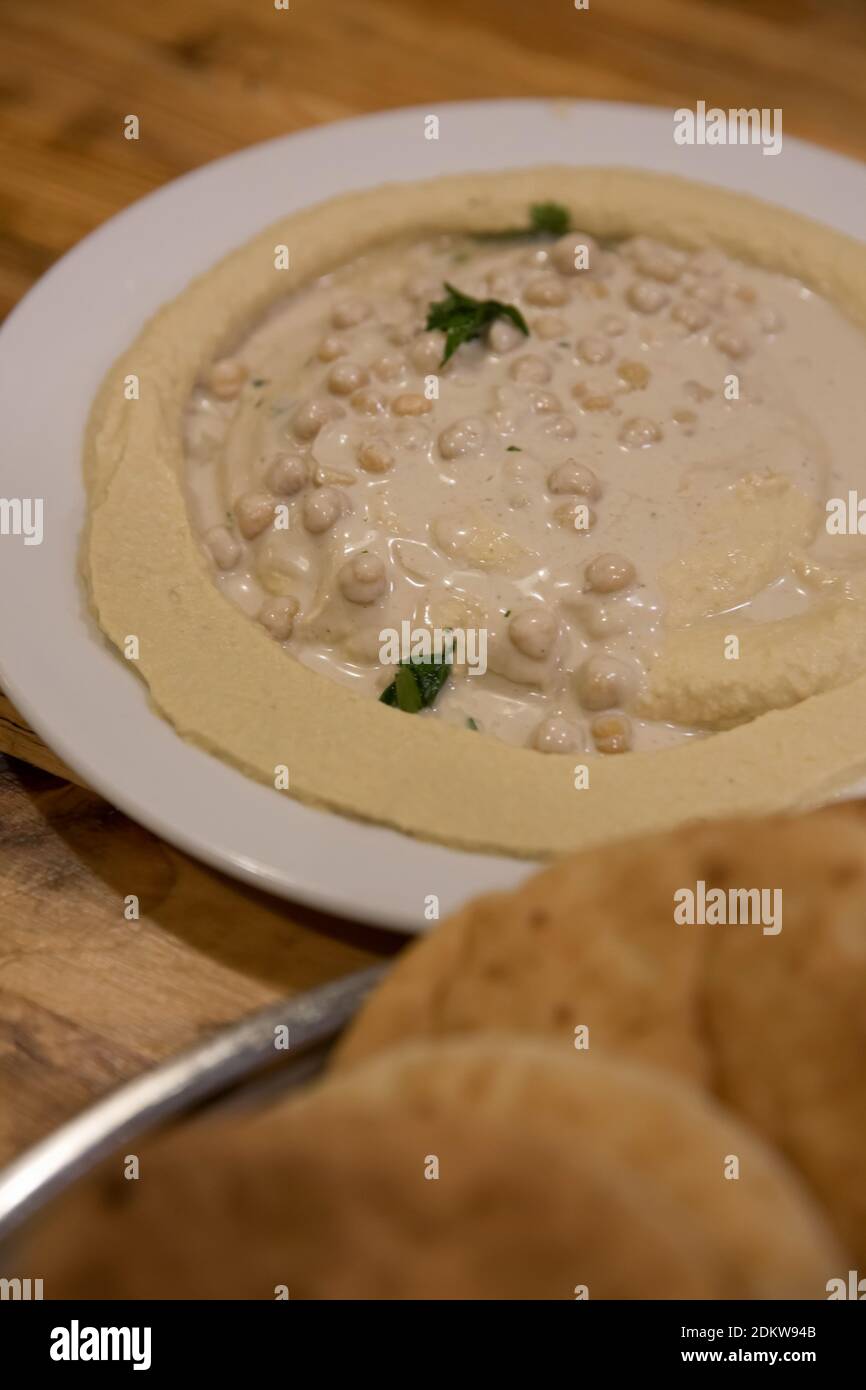 Eine Portion Humus, Tahini, Olivenöl und Petersilie eine mittelöstliche Paste aus Kichererbsen Stockfoto