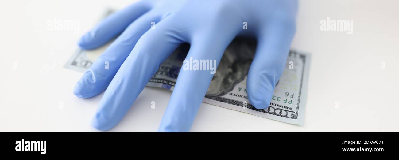 Ärzte Hand in Gummihandschuh hält Dollar Rechnung in der Klinik Nahaufnahme Stockfoto