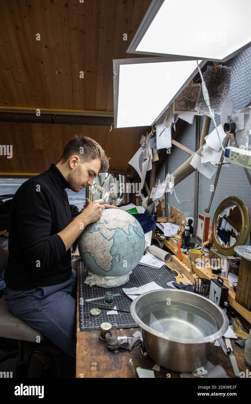 Eine Menschenhand malt bei Bellerby & Co Globemakers in Stoke Newington, London, Großbritannien, einen Globe Atlas, den größten handgefertigten Globus der Welt mit einem Durchmesser von 50 cm Stockfoto