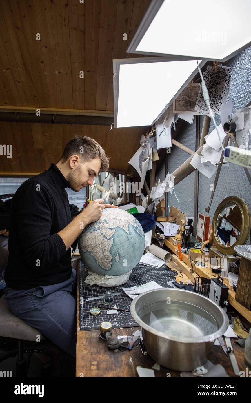 Eine Menschenhand malt bei Bellerby & Co Globemakers in Stoke Newington,  London, Großbritannien, einen Globe Atlas, den größten handgefertigten  Globus der Welt mit einem Durchmesser von 50 cm Stockfotografie - Alamy