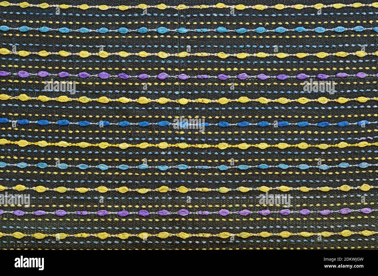 Mehrfarbige Wollleinwand als Hintergrund mit violett gelb blauen Fäden Stockfoto