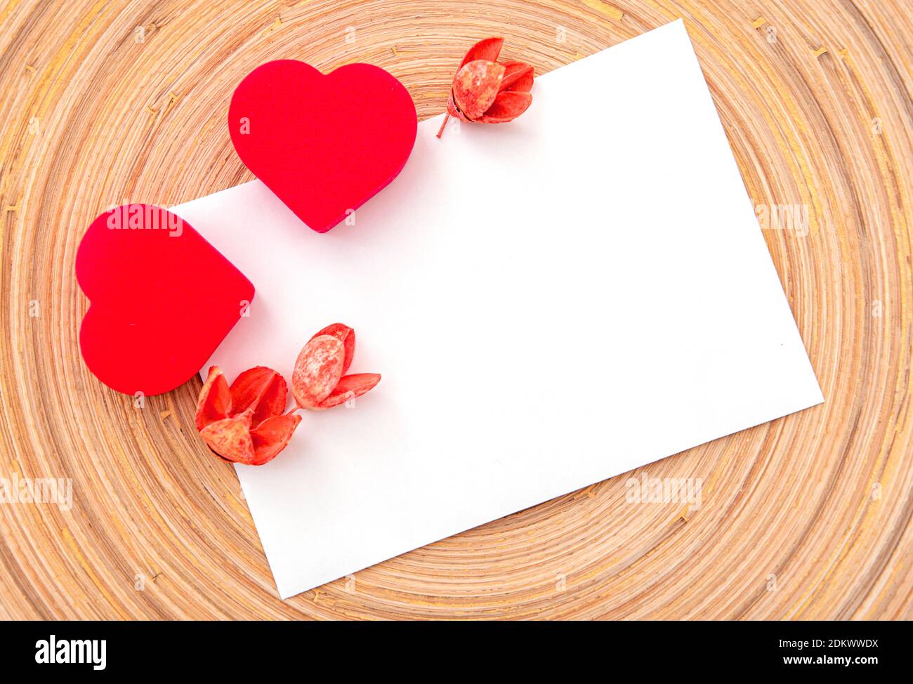 Zwei rote Herzen und trockene Blumen auf weißem Blatt, Layout, Platz für Text. Postkarte für Valentinstag oder Hochzeitsfeier Stockfoto
