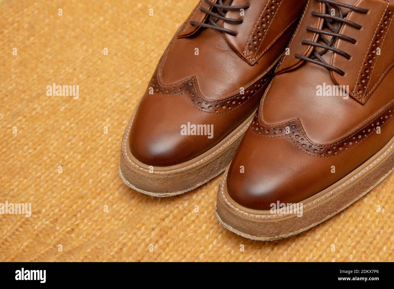 Luxus-Schnürschuhe aus braunem Leder für Geschäftsleute auf gestricktem Hintergrund. Nahaufnahme Stockfoto