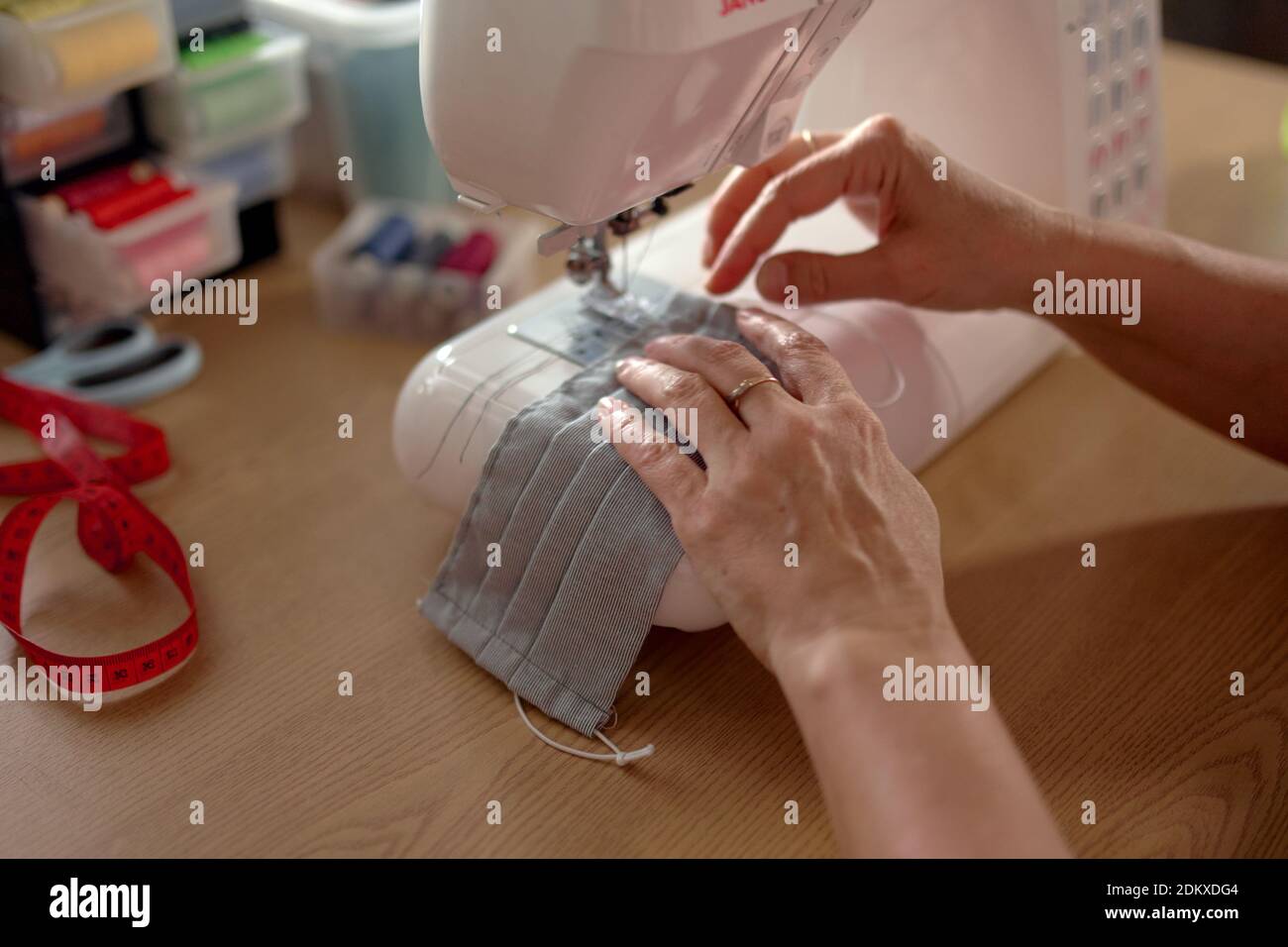 Frau Hände mit der Nähmaschine, um das Gesicht zu nähen Maske Stockfoto