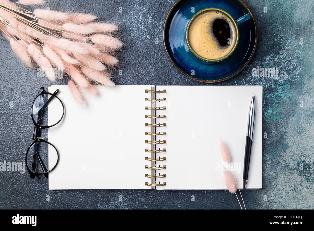 Offene weiße leere Notebook, Kaffeetasse, rosa getrocknete Blumen Blumenstrauß auf Schreibtisch des Home Office Wohnung lag. Freiberuflich, Blogging, feminin, Arbeitskonzept top Stockfoto