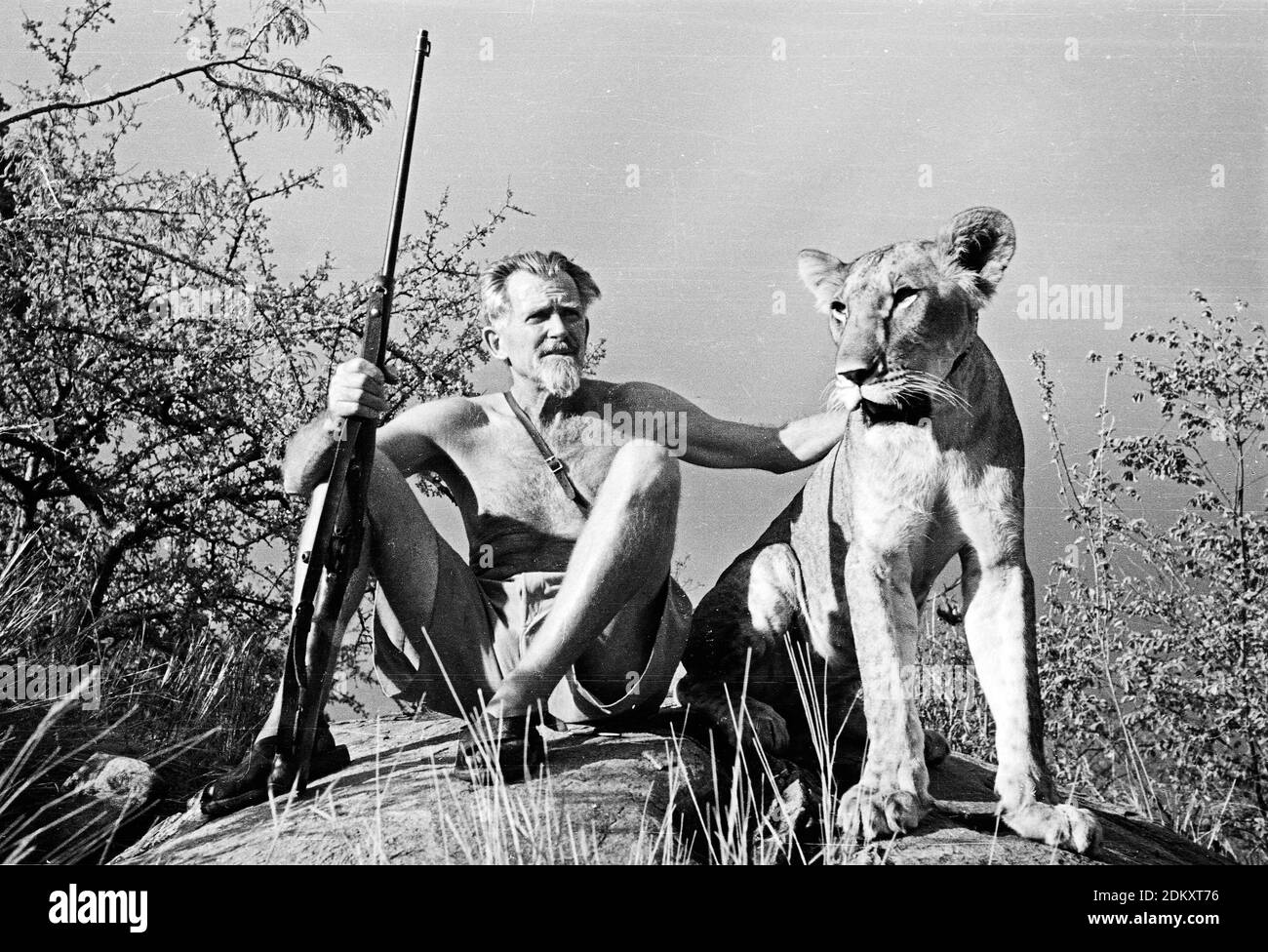 George Adamson, ehemaliger Game Warden in Kenia, sitzt auf einem Felsvorsprung mit Elsa, der Löwin von Born Free Fame. Kenia. Stockfoto