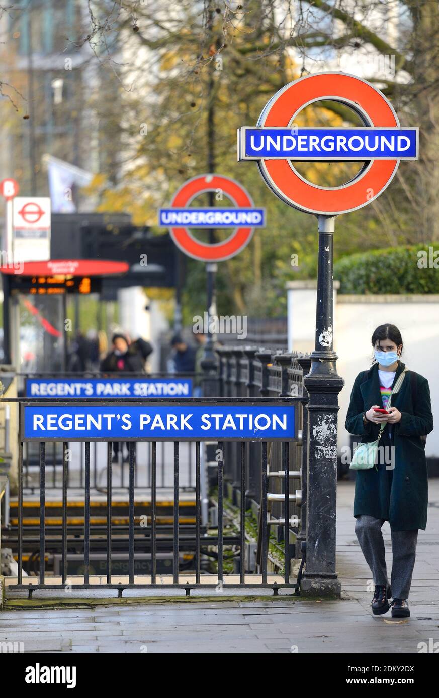 London, England, Großbritannien. Eingang zur U-Bahn-Station Regent's Park an der Marylebone Road. Junge Frau am Telefon und trägt eine Gesichtsmaske während der COVID Stockfoto