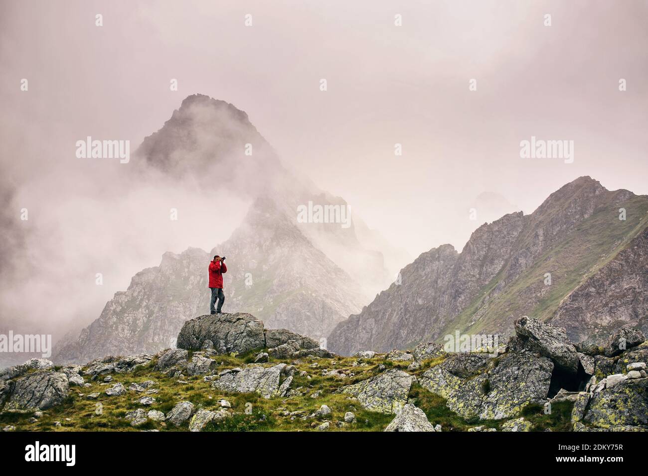 Wanderer mit Kamera auf einem Berg stehend Stockfoto