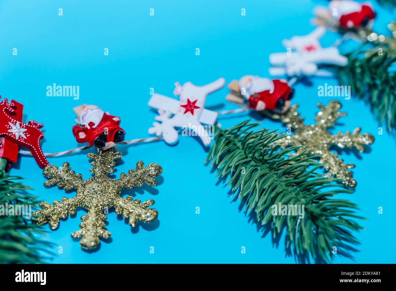 Weihnachtskomposition. Girlande aus goldenen Schneeflocken und Tannenzweigen auf blauem Hintergrund. Weihnachten, Winter, Neujahr Konzept. Stockfoto