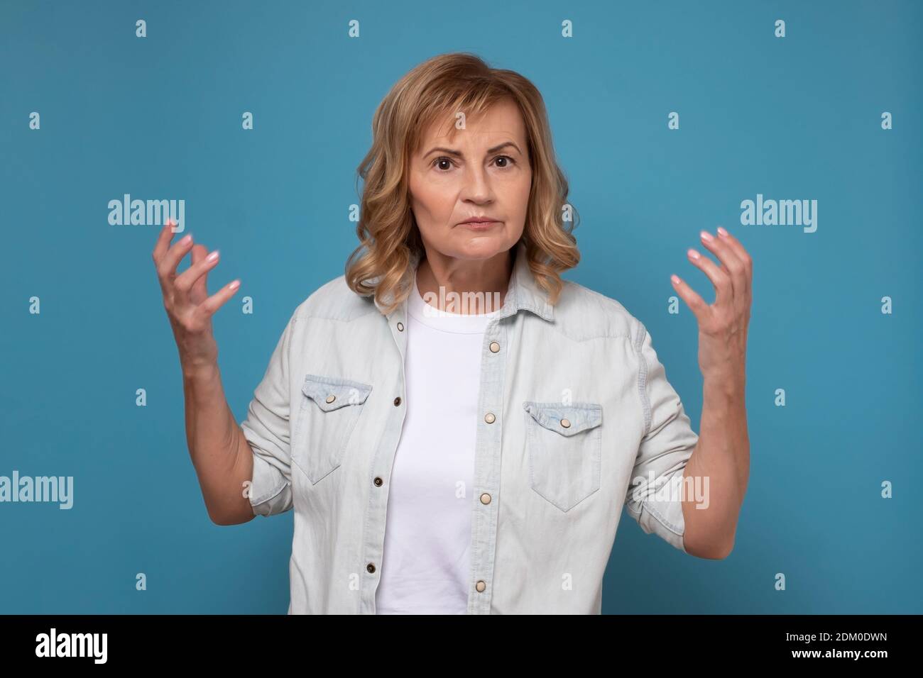 Verstörte kaukasische Frau, die verwirrt fragte, was Ihr von mir wollt. Studioaufnahme Stockfoto