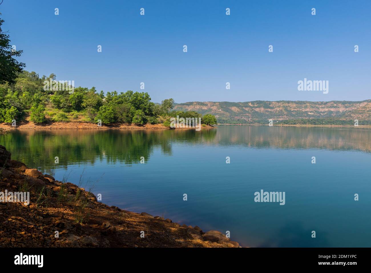 Panoramablick auf schöne Panshet Damm mit üppigen grünen Bäumen an der Küste an einem sonnigen Morgen. Der Damm befindet sich in Pune, Maharashtra, Indien Stockfoto