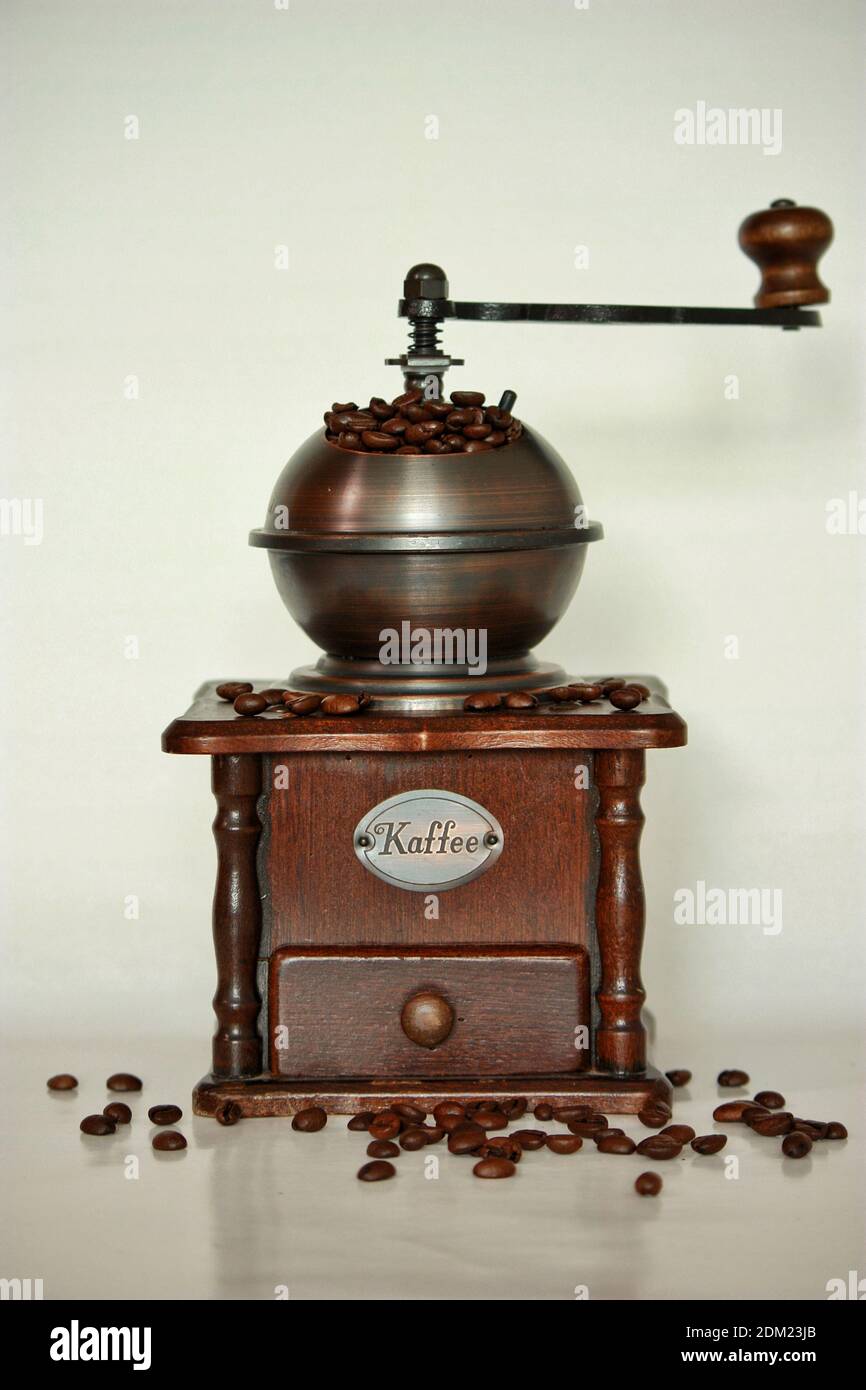 Traditionelle hölzerne Kaffeemühle gefüllt mit Bohnen Stockfoto