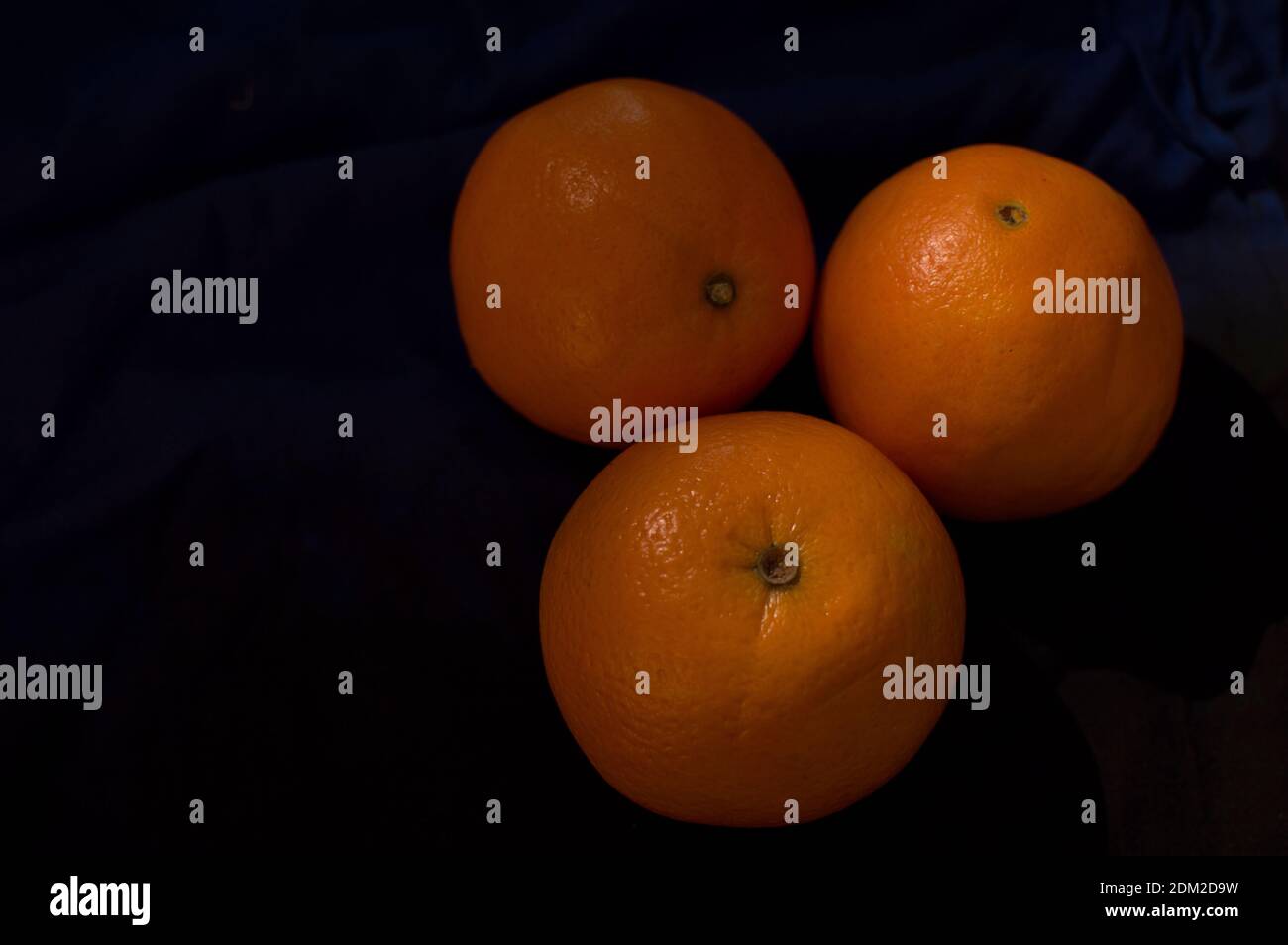 Drei Orangen mit schwarzem Hintergrund Stockfoto