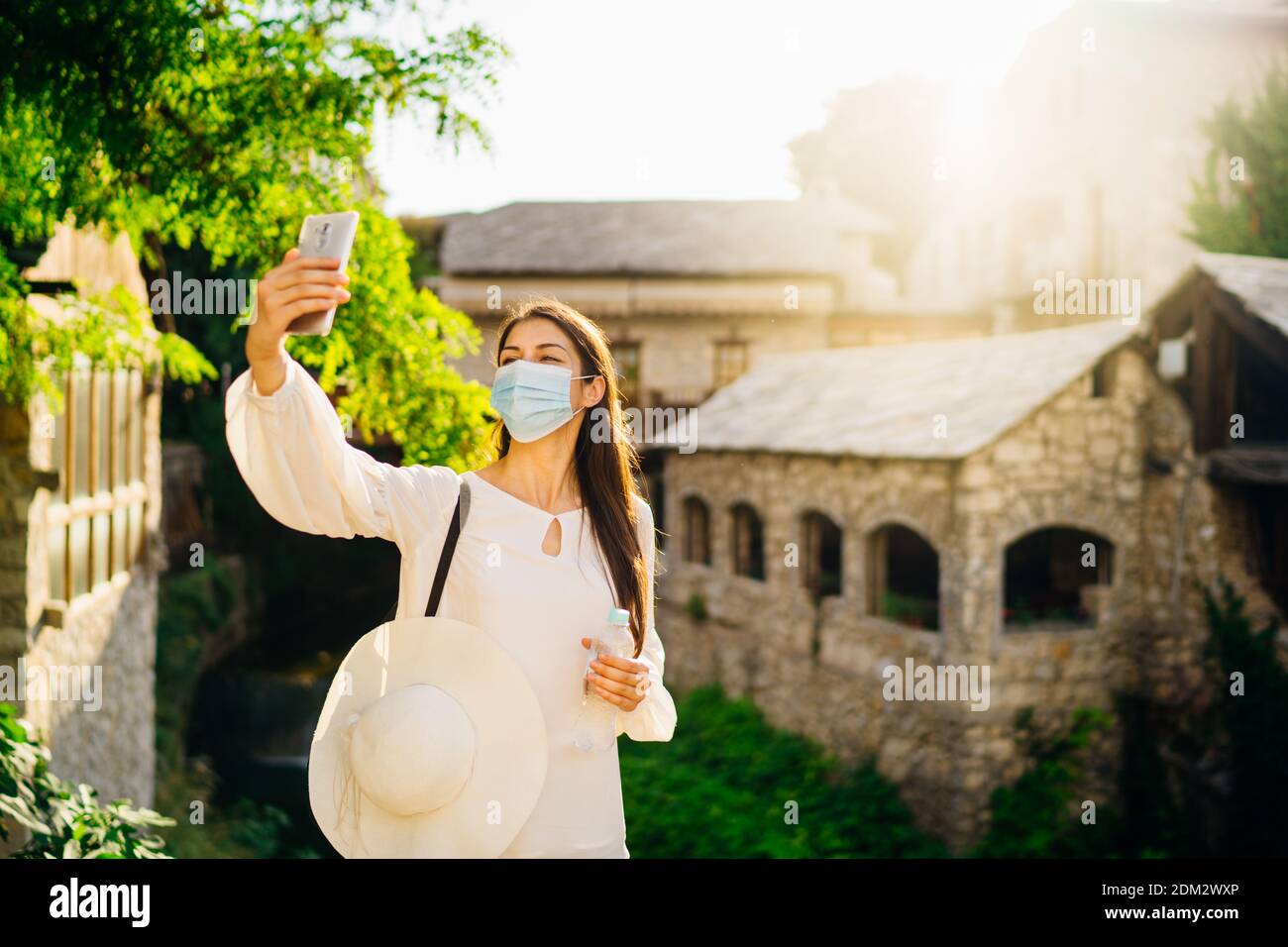 Junge Touristenfrau mit Gesichtsmaske, die während des Coronavirus-Pandemieausbruchs in europäische Städte reist. Reisen Sie nach Europa unter COVID-19. Besuch lokal Stockfoto
