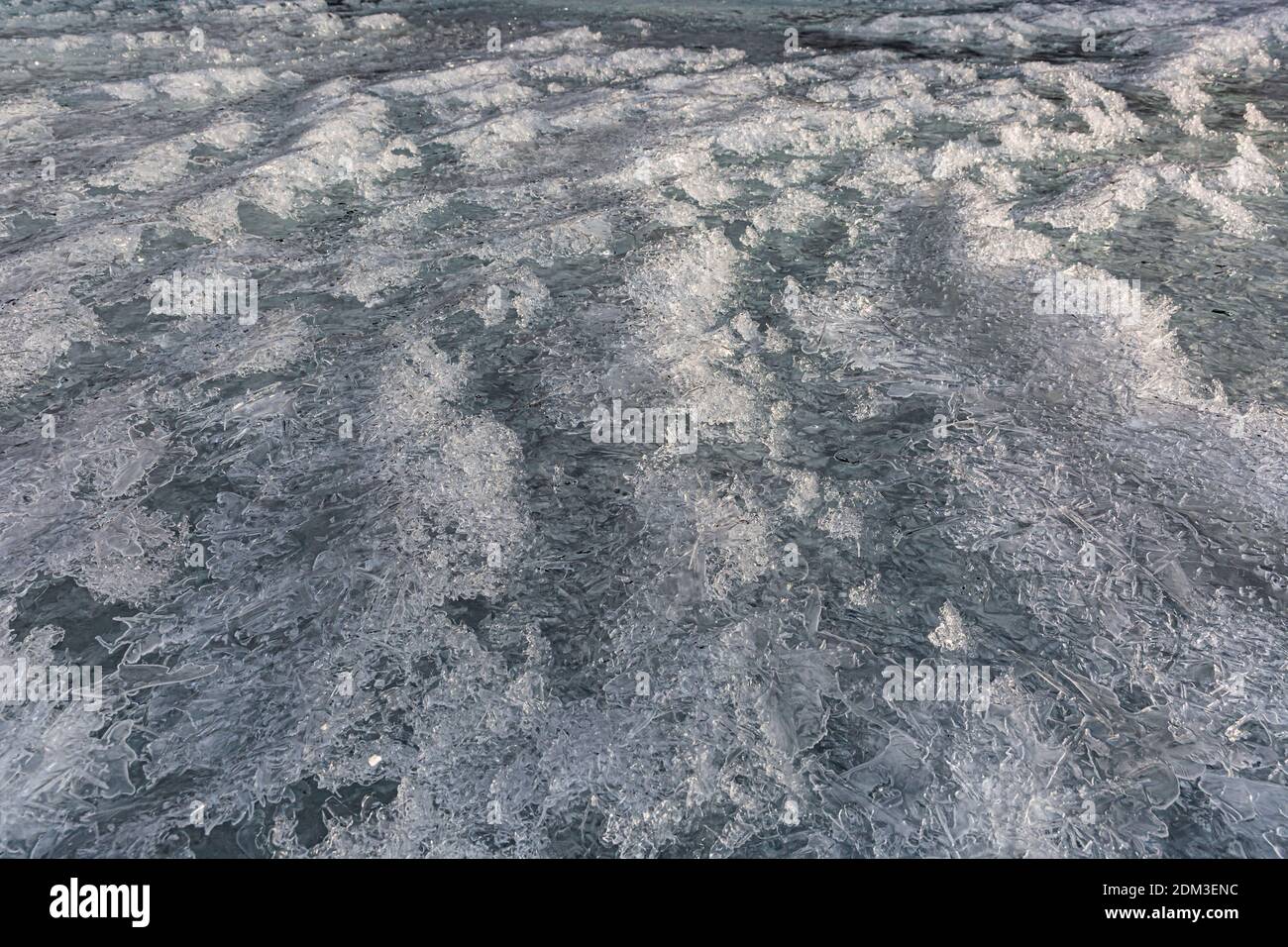 Nahaufnahme einer gefrorenen Wasseroberfläche im Winter. Gefrorene Eisstruktur. Eishintergrund für weihnachten. Gefrorener Fluss in der Schweiz aufgenommen. Stockfoto