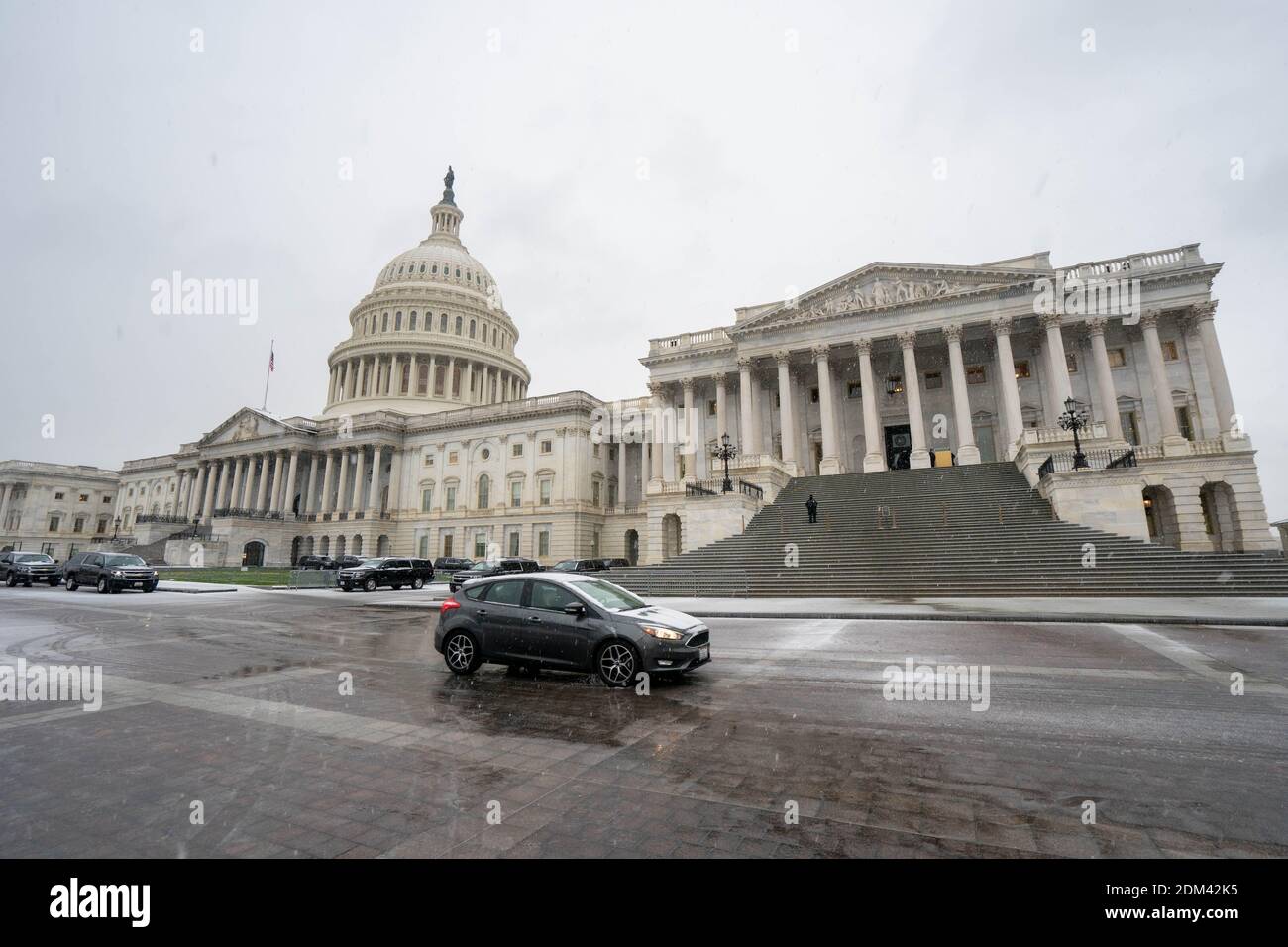 Washington, Usa. Dezember 2020. Ein Auto fährt durch das US-Kapitol, als der erste Schnee Washington, DC, 16. Dezember 2020 trifft. Die Kongressführer sind kurz vor der Einigung, ein Hilfspaket im Wert von rund 900 Milliarden Dollar um eine neue Runde von Konjunkturüberprüfungen zu ergänzen, da sie sich beeilen, ein Abkommen vor Ende der Woche abzuschließen. Foto von Ken Cedeno/Sipa USA Quelle: SIPA USA/Alamy Live News Stockfoto
