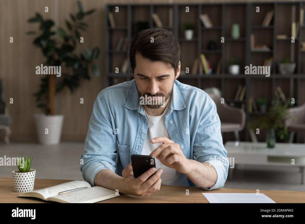 Kaukasischer Mann verwenden modernes Smartphone zu Hause Stockfoto