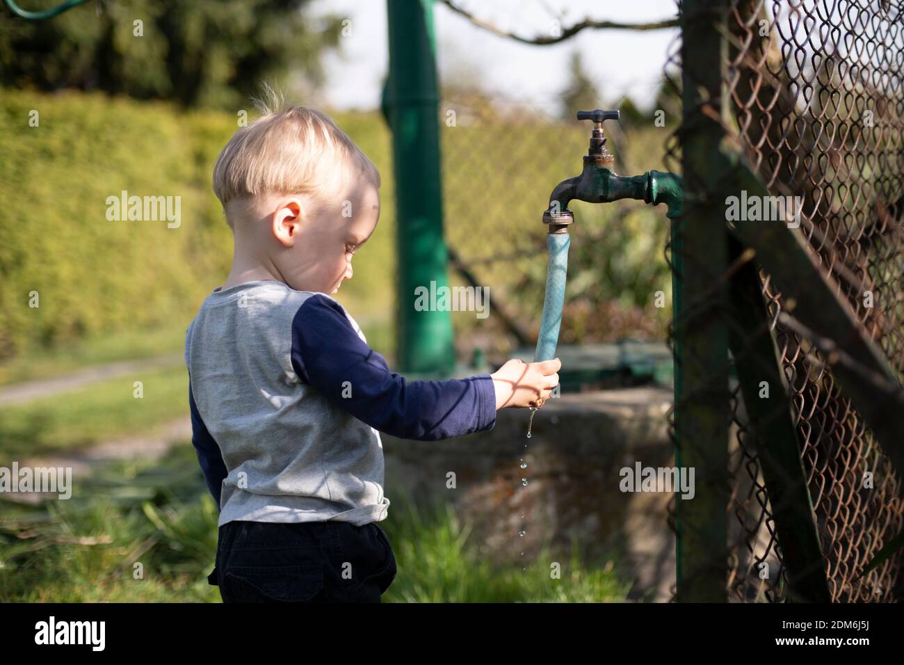 Junge Hände Waschen Unter Gartenhahn Stockfoto