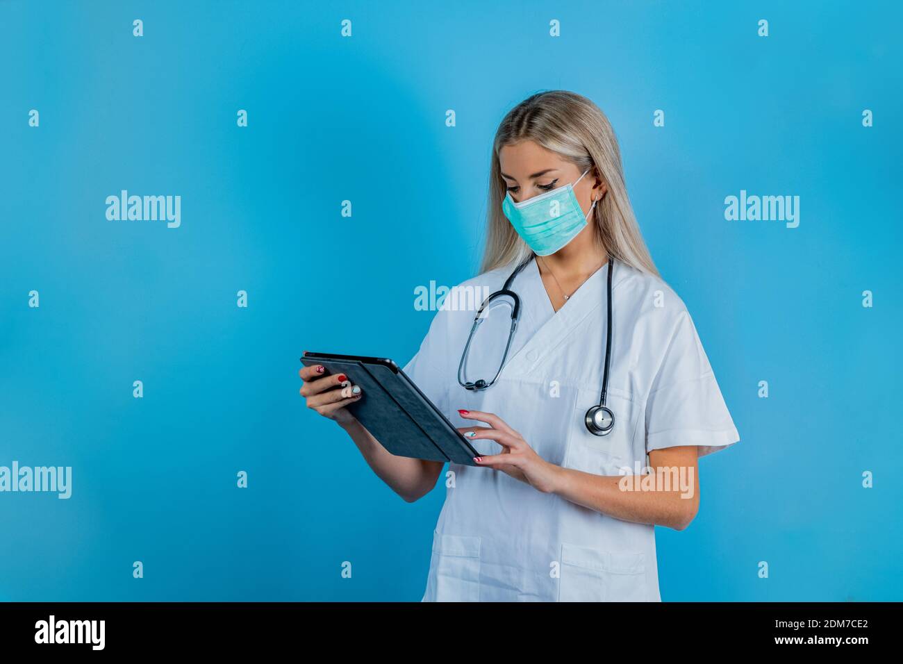 Nahaufnahme der Ärztin oder Wissenschaftlerin in Schutzkleidung mit medizinischer Maske zum Schutz vor Viruserkrankungen mit Tablet-Computer. Sicherheit im Arbeitsschutz Stockfoto