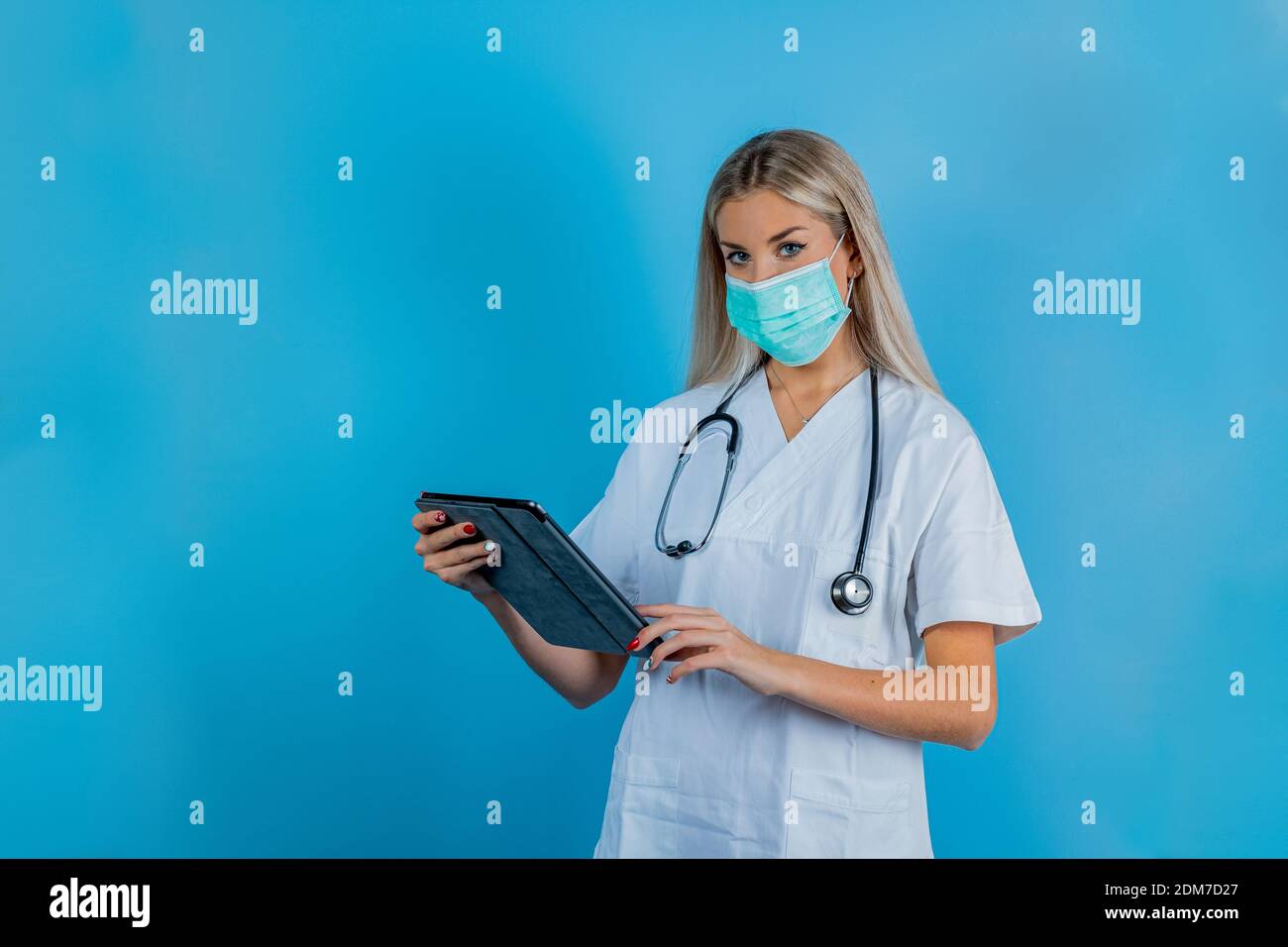 Nahaufnahme der Ärztin oder Wissenschaftlerin in Schutzkleidung mit medizinischer Maske zum Schutz vor Viruserkrankungen mit Tablet-Computer. Sicherheit im Arbeitsschutz Stockfoto