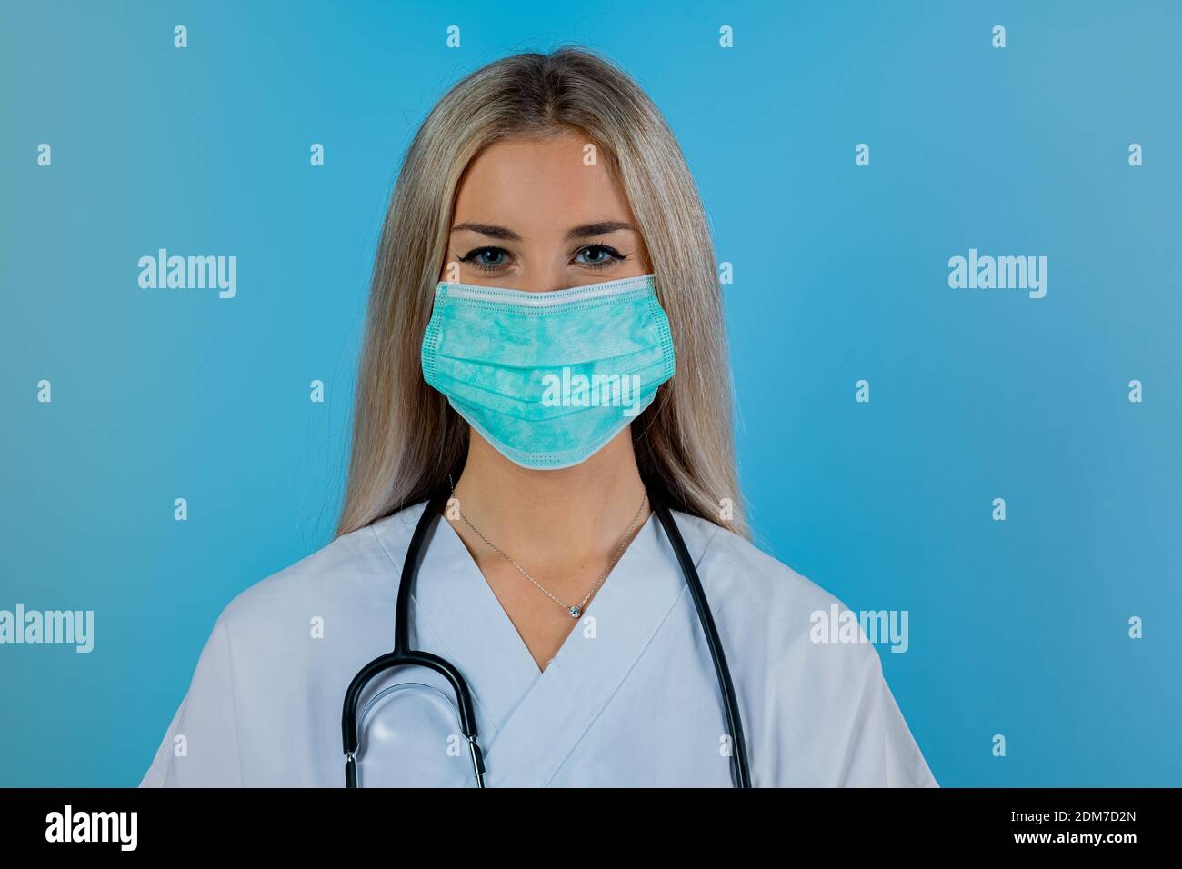 Portrait von professionellen selbstbewussten jungen Arzt trägt medizinische Maske, weißes Fell, Stethoskop, bereit helfen Patienten, Krankheit zu bekämpfen. Covid19, Coronavirus Stockfoto