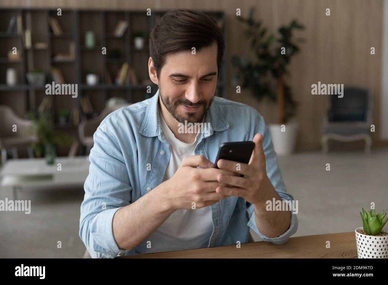 Glücklicher Mann Blick auf Handy-Bildschirm SMS Stockfoto
